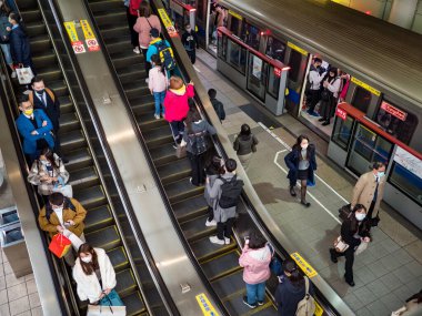 Taipei, Tayvan 'da 2 Aralık 2021' de toplu taşıma sisteminde yüz maskesi takan yolcular. 19 numaralı kovid19 salgını tüm dünyada sayısız ölüme yol açtığı için.