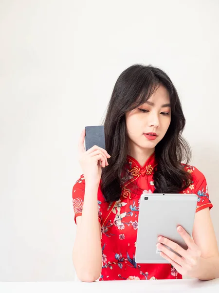 亚洲女青年穿着传统旗袍 在网上使用数码平板电脑和信用卡购物 电子商务概念与白人背景隔离 — 图库照片