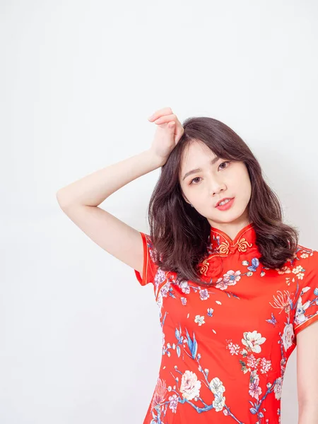 Geleneksel Cheongsam Qipao elbisesi giyen güzel Asyalı kadın beyaz arka planda çaresizlikten kıvranıyor..