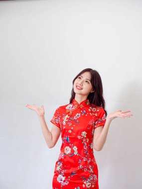 Geleneksel Cheongsam Qipao elbisesi giyen Asyalı genç bir kadının portresi izole edilmiş beyaz arka plan üzerinde iki eliyle kopyalama alanı tutuyor..