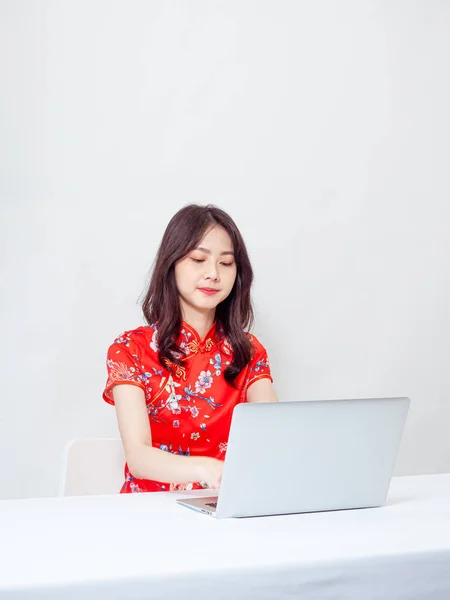一个身穿传统旗袍的年轻亚洲女人的画像 她穿着白色背景的笔记本电脑 — 图库照片