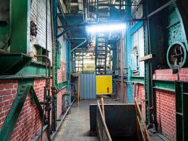 Boruları ve paslı metal yapıları olan terk edilmiş bir fabrikanın içini.