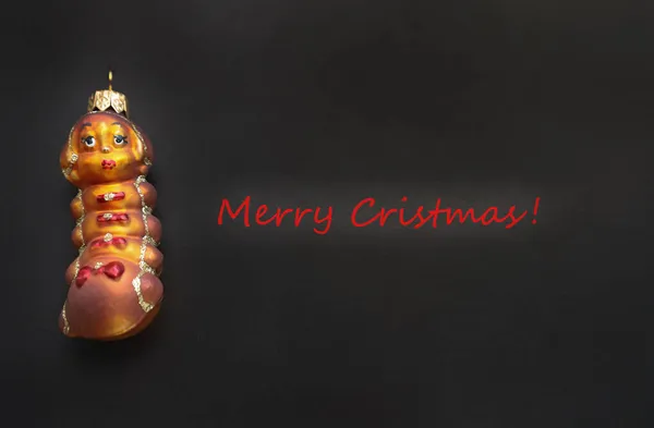 Mutlu yıllar ve Noel 'ler. Tebrik kartı. Bir tırtıl şeklinde koyu renk bir arka plan oyuncağıyla. nadirlik