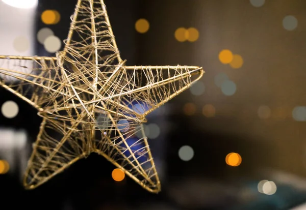 Karanlık arka planda bir noel yıldızı. Boke etkisi. Gerilmiş iplikleri olan metal yapı.