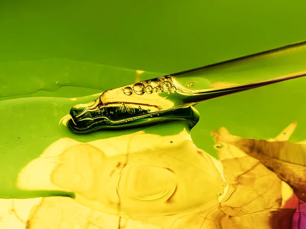 Tekuté Sérum Kapátko Zeleném Žlutém Pozadí Listovou Strukturou Pohled Zepředu — Stock fotografie