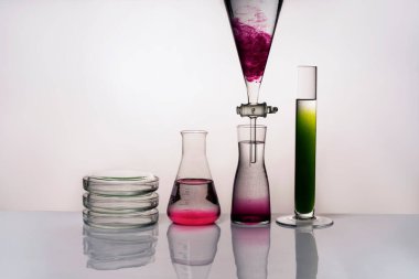 Laboratuvar ekipmanları ve sıvılarla tıbbi ya da kimyasal geçmişi var. Hafif bir arkaplanda, ön görünüm.