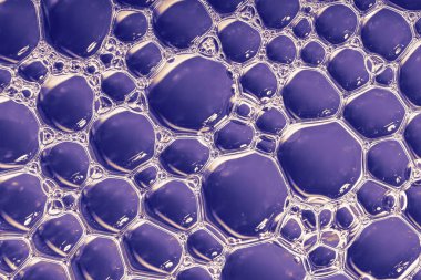 Mavi arka planda sıvı kabarcıkları. Baloncuklu yağ ya da serum arka planı. Üst görünüm