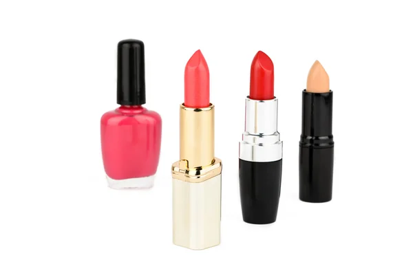 Three lipstick and a nail polish — Stock Photo, Image