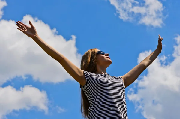 Girl with arms raised in sun glasses — Stock Photo, Image