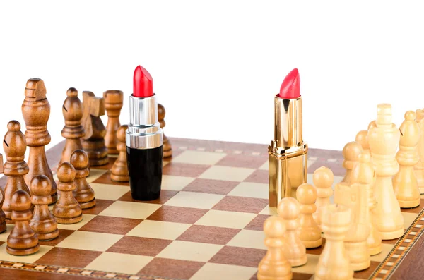 Two lipsticks on the battlefield of chess — Stock Photo, Image