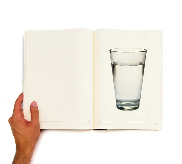 Waterglas vol water gedrukt op wit boek. — Stockfoto