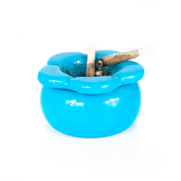 Posacenere blu con sigarette usate che rotolano all'interno su sfondo bianco — Foto Stock