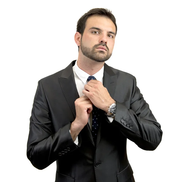 Businessman putting on a necktie over white background — Stock Photo, Image