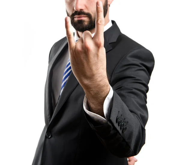 Young businessman doing the horn sign over white background — Stock Photo, Image