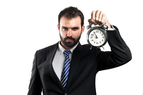 Joven hombre de negocios sosteniendo un reloj antiguo sobre fondo blanco —  Fotos de Stock