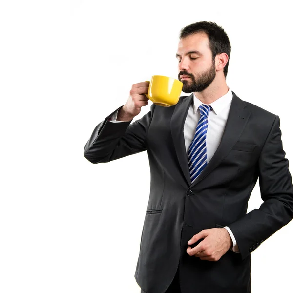 Giovane uomo d'affari bere un caffè su sfondo bianco — Foto Stock