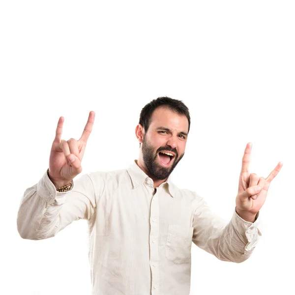 Jovem fazendo o sinal de chifre sobre fundo branco — Fotografia de Stock