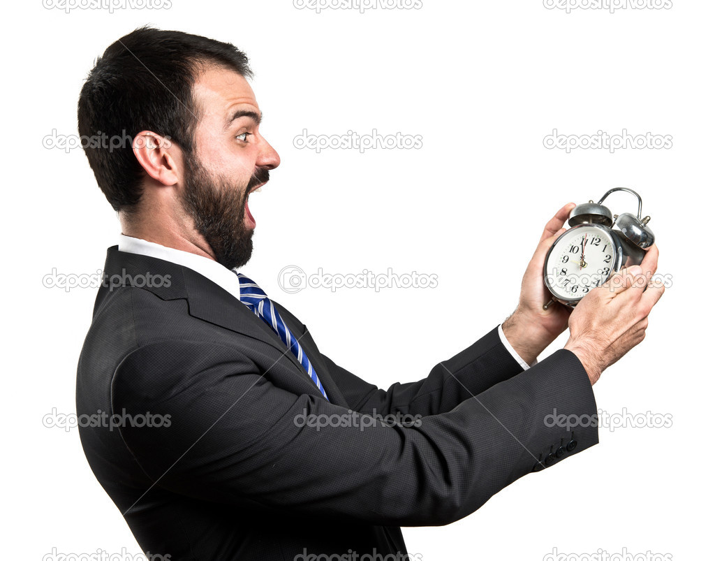 Young businessman holding an antique clock over white background