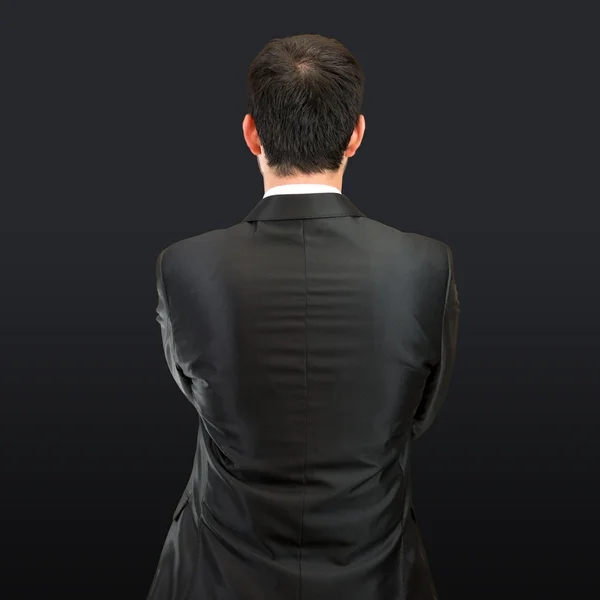 Businessman back over isolated black background — Stock Photo, Image