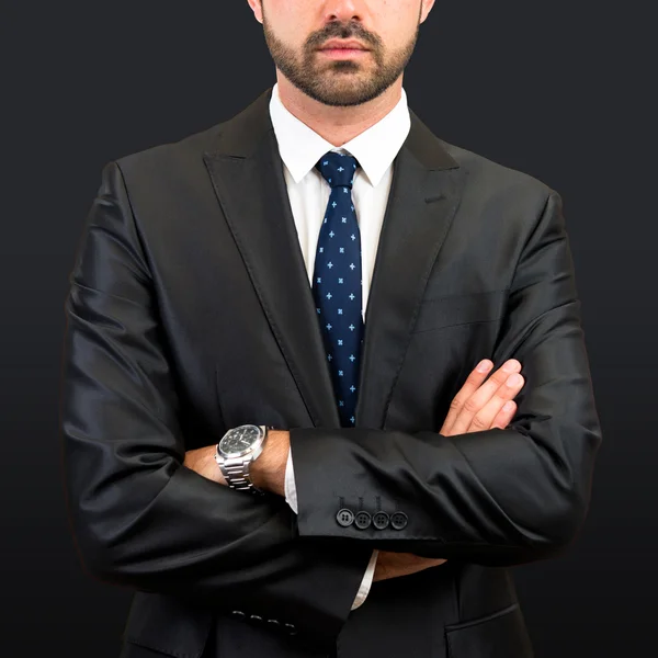 Business man with his arms crossed over isolated black background — Stock Photo, Image