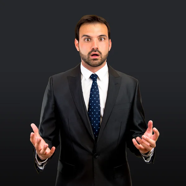 Fear business man over isolated black background — Stock Photo, Image