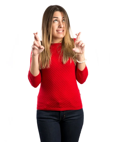 Chica joven cruzando sus dedos sobre fondo blanco — Foto de Stock