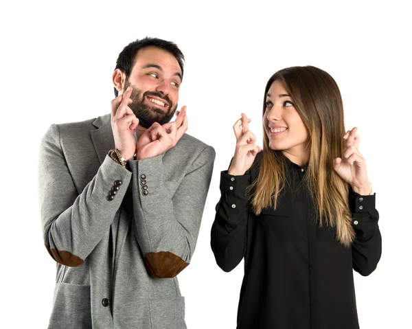 Couple with their fingers crossing over white background — Stock Photo, Image