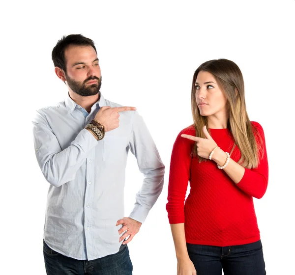 Couple pointing each other over white background — Stock Photo, Image