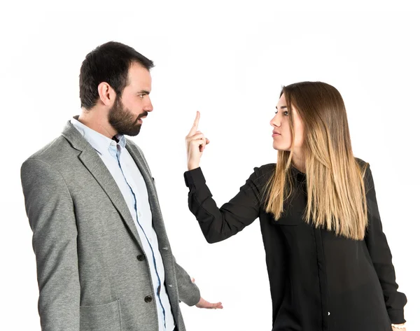 Girl doing the horn sign at her boyfriend over white background — Stock Photo, Image