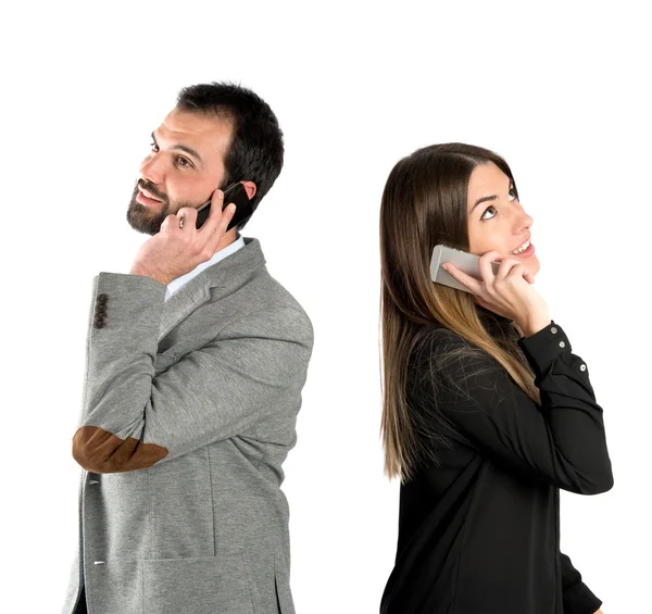 Couple talking to mobile over isolated background. — Stock Photo, Image