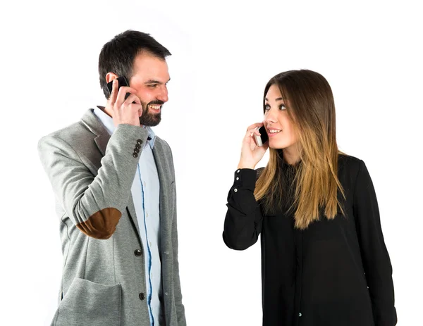 Couple talking to mobile over isolated background. — Stock Photo, Image