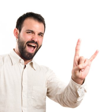 Beyaz arka plan üzerinde boynuz işareti yapan genç erkek