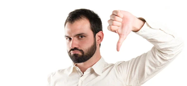 Young man with thumbs down over white background — Stock Photo, Image