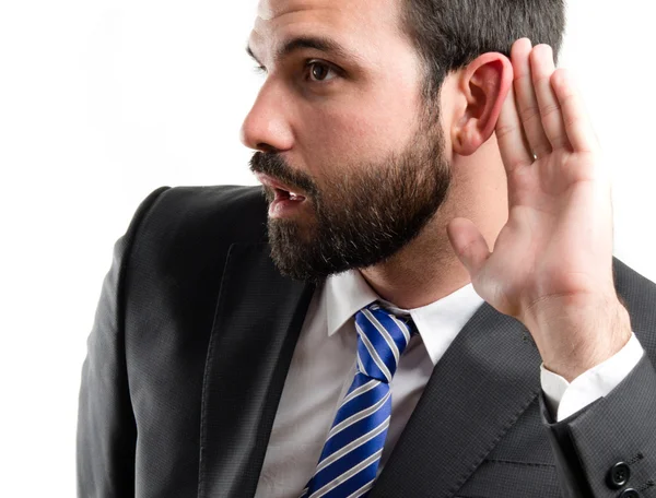 Young business man hearing something over white background — Stock Photo, Image