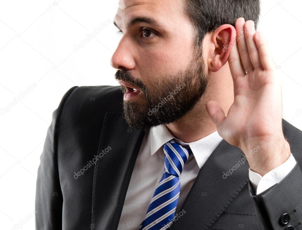 Young business man hearing something over white background