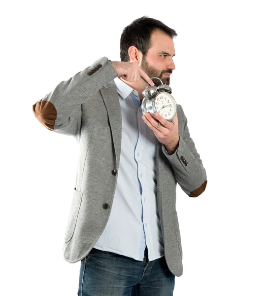 Joven hombre de negocios sosteniendo un reloj antiguo sobre fondo blanco — Foto de Stock