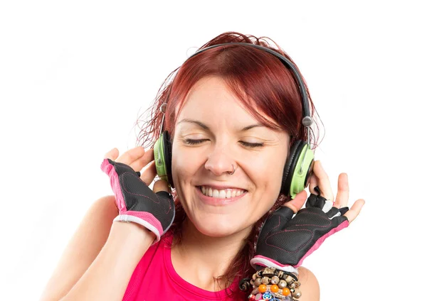 Joven chica del deporte escuchando música sobre fondo blanco —  Fotos de Stock