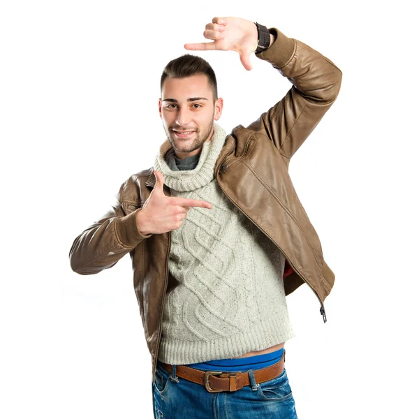 Young man doing a frame sign over white background — Stock Photo, Image
