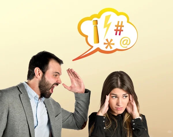 Businessman screaming at his girlfriend over yellow background — Stock Photo, Image