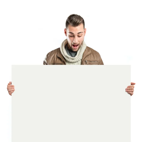 Handsome man holding an empty cardboard over white background — Stock Photo, Image