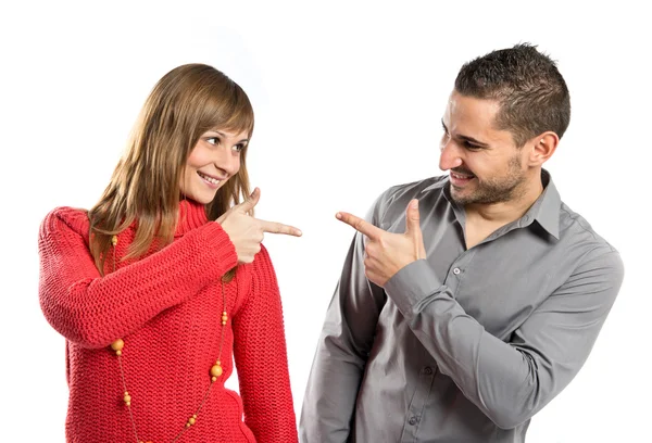 Couple pointing each other over white background — Stock Photo, Image