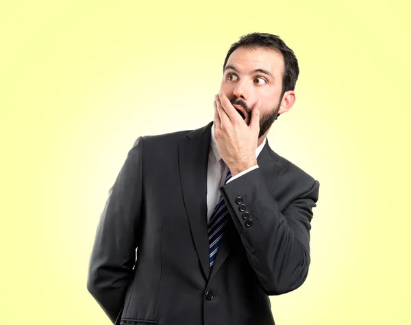 Businessman surprised over yellow background — Stock Photo, Image