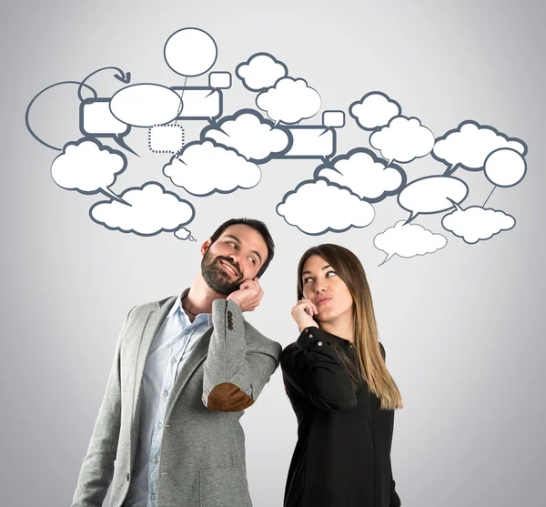 Pareja hablando con móvil sobre fondo gris . — Foto de Stock