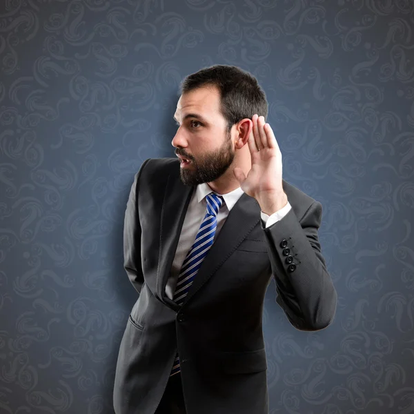 Young business man hearing something over vintage background — Stock Photo, Image