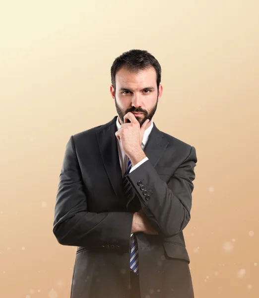 Business man thinking over ocher background — Stock Photo, Image