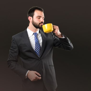 genç işadamı siyah arka plan üzerinde bir kahve içme