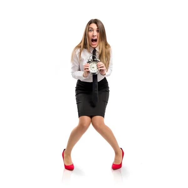 Young businesswoman holding an antique clock over white background — Stock Photo, Image