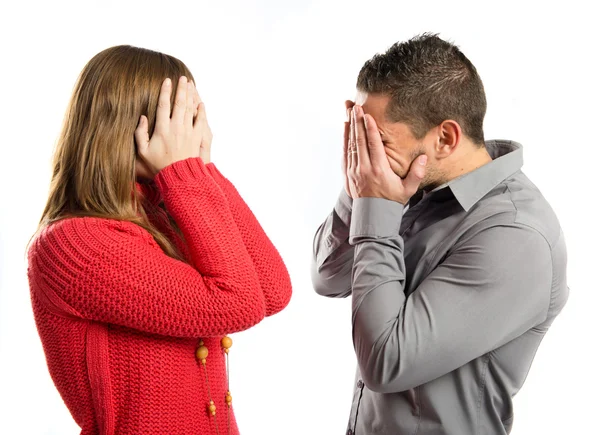 Pareja cubriendo sus ojos sobre fondo blanco — Foto de Stock