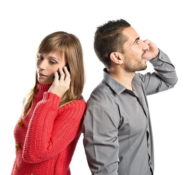 Couple talking to mobile over isolated background. — Stock Photo, Image