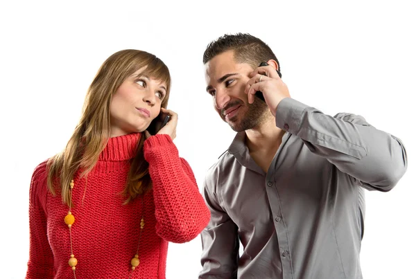 Couple talking to mobile over isolated background. — Stock Photo, Image